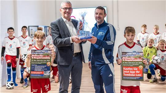 Christoph Born, Geschäftsführer der Stadtwerke Stade, präsentiert mit der Stader U12 die große Tombola anlässlich des Hallenzaubers des VfL Güldenstern Stade.