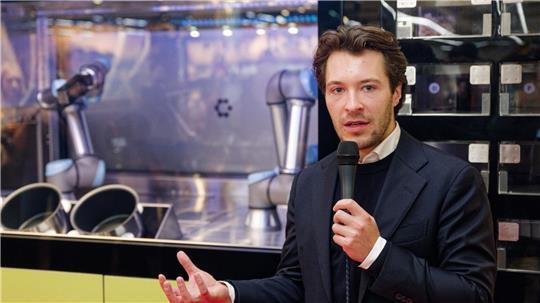 Circus-Gründer Bullwinkel spricht bei der Vorstellung des Kochroboters CA-1 in einem Rewe-Markt. (Archivbild) 