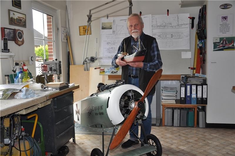 Claus Stöven zeigt in seiner Werkstatt einen Kümo, an dem er gerade baut, und den Doppeldecker Fokker-D.VI mit 5-Zylinder Sternmotor 250 Kubikzentimeter, transportbereit ohne Flügel. Foto: Lankuttis
