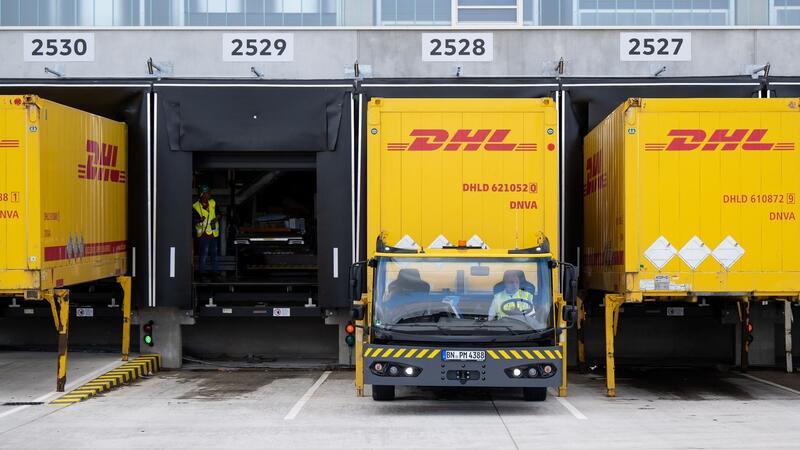 DHL nimmt neues Paketzentrum in Neumünster in Betrieb Container und Fahrzeuge mit dem Logo von DHL stehen an einem DHL-Paketzentrum.