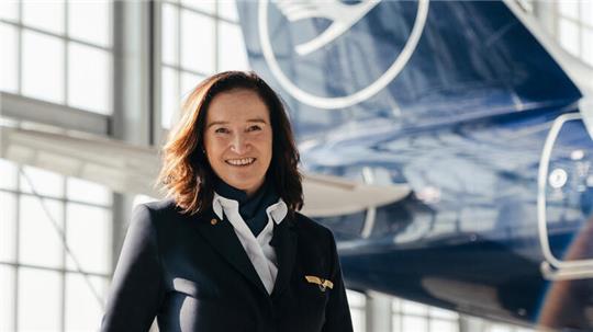 Cordula Pflaum, Flugkapitänin der Lufthansa, steht vor einem Flugzeug.