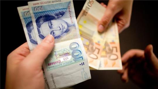 D-Mark-Scheine werden gegen Euro-Scheine symbolisch getauscht.