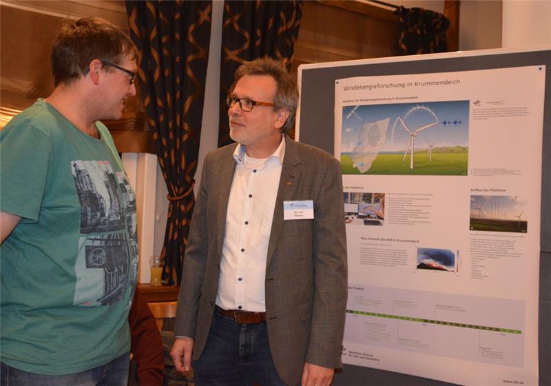 DLR-Ingenieur Jan Teßmer (rechts) erklärt einem interessierten Besucher, wie die Testanlage aufgebaut ist.