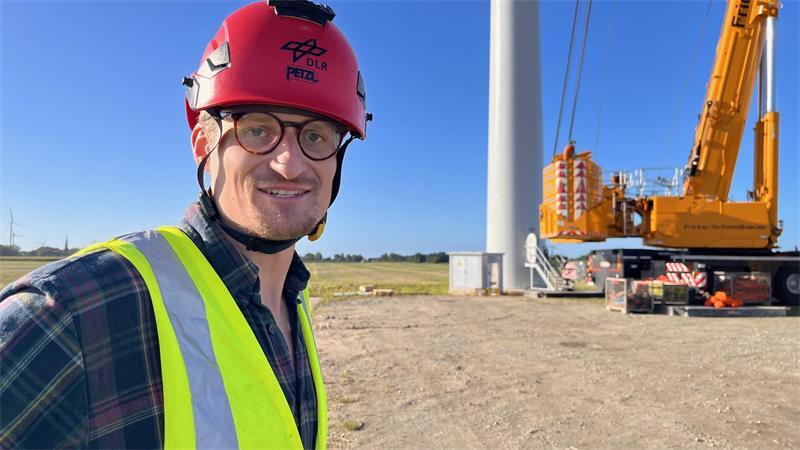 29 Tonnen am Haken: In Krummendeich entsteht ein begehrtes Forschungsobjekt DLR-Ingenieur und Projektleiter Lukas Firmhofer auf der Baustelle in Krummendeich. So richtig entspannen wird er sich wohl erst, wenn jedes Anlagen-Teil fest verankert an seinem Platz ist.