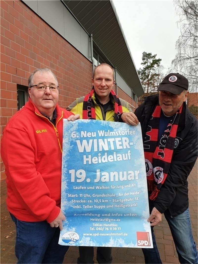 DLRG-Chef Matthias Groth, Tobias Handtke (SPD) und Manfred Grabbert vom TVV zeigen das Plakat für den Heidelauf.