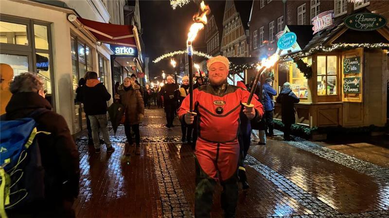 Stade: Fackelschwimmer stürzen sich am Fischmarkt ins kalte Wasser DLRG-Einsatztaucher Sascha Schumacher führte im Trockentauchanzug den Fackelzug an.