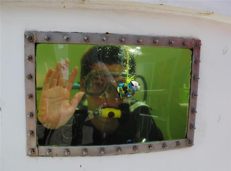 DLRG-Rettungstaucher Jonathan Lehmbecker winkt Besuchern zu.