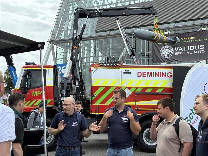 Auf Mission in Hannover: Buxtehuder Wasserretter rüsten sich DLRG-Wasserretter aus Stade und Buxtehude am Stand, im Hintergrund die kriegserprobten Ukrainer.