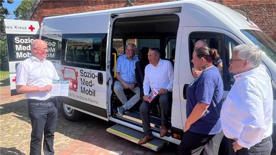 DRK-Projektleiter Detlef Stülten stellt den Bürgermeistern Matthias Riel und Timo Gerke das Sozio-Med-Mobil mit den Fahrern Lutz Benold und Stefanie Groß sowie DRK-Präsident Michael Roesberg in Steinkirchen vor (von links).