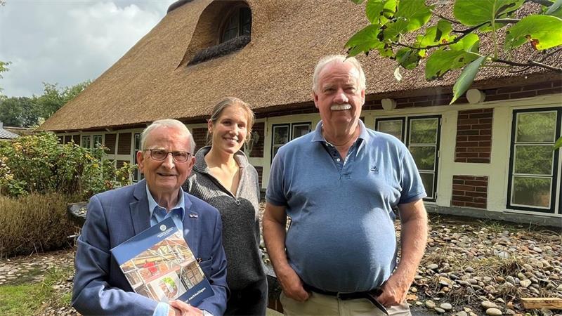 DSD-Ortskurator Reinhold Holck, Kim Sulinski und Denkmaleigentümer Marcus Müller (von links) vor dem frisch gedeckten Reetdach.