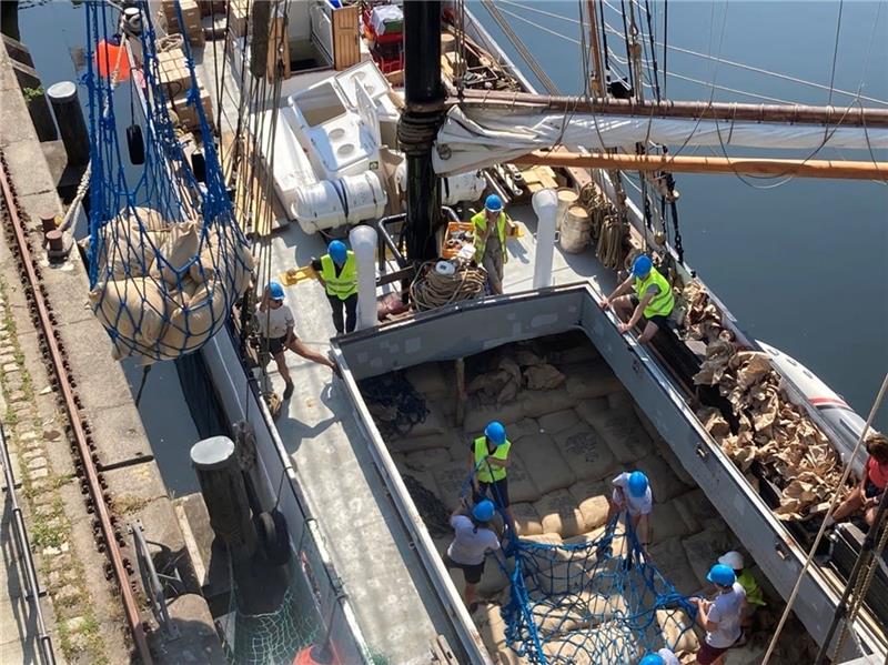 Da ist die Hälfte bereits gelöscht: Freiwillige beladen das Netz des Kulturkrans mit Kaffeesäcken aus dem Laderaum des Segelfrachters Avontuur. Der denkmalgeschützte Kran hievt dann pro Hebevorgang die rund 300 Kilogramm schwere Ladung an den Lotsekai. Foto: MuHaHar