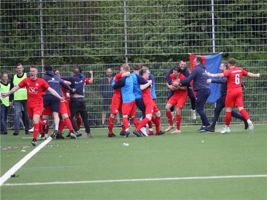 Da sind alle Dämme gebrochen: Alle Ahlerstedter stürmen nach dem 4:3-Siegtreffer auf den Platz und feiern mit den Spielern.