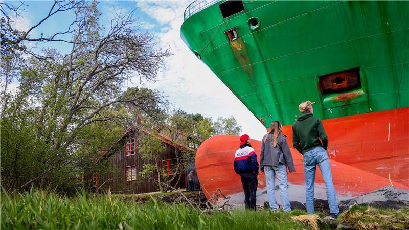 Norwegen: Auf Grund gelaufenes Containerschiff geborgen Da steht ein Containerschiff im Garten.