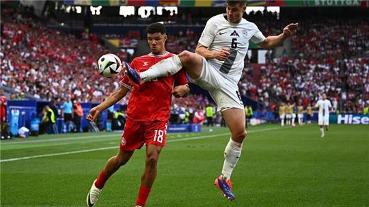 Dänemarks Alexander Bah und Sloweniens Jaka Bijol (r) kämpfen um den Ball.