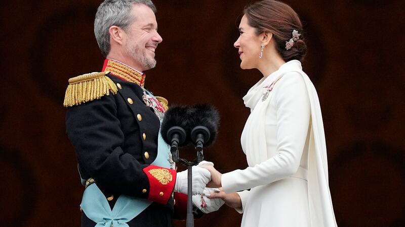 Dänemarks König Frederik X. und Dänemarks Königin Mary halten sich auf dem Balkon von Schloss Christiansborg die Hände.