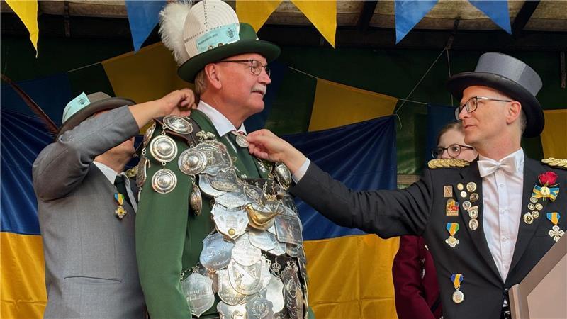 Damit alles ordentlich sitzt: Gilde-Vorsitzender Reinhard Meier (rechts) zupft am neuen König Jürgen Meyer den sogenannten Taler zurecht - eine Medaille der Freien und Hansestadt Hamburg mit viel Tradition.