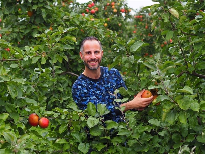Daniel E. Palu mit dem Apfelbaum in Jork , für den der Autor eine Patenschaft übernommen hat. Foto: Ralf Grobe