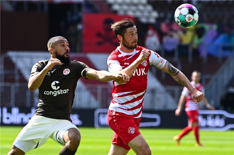 Daniel Kofi Kyereh (l) vom FC St. Pauli kämpft um den Ball mit Christian Strohdiek (r) vom FC Würzburger Kickers. Foto: Oliver Hardt/dpa