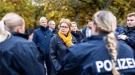 Daniela Behrens (SPD, M), Innenministerin von Niedersachsen, spricht mit Einsatzkräften der Polizei vor dem Stadion.