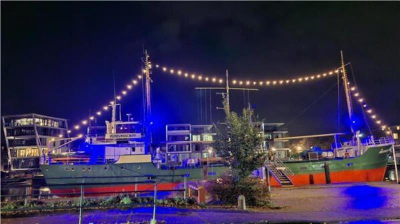 Dank Beleuchtung strahlt das Museumsschiff Greundiek in der Dunkelheit als Blue-Port-Stade.