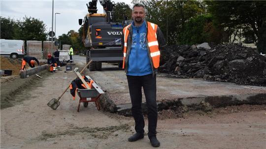 Danny Berkhahn (Rischkau Straßen- und Tiefbau GmbH) leitet die Straßenbaustelle der gesperrten Straße Westmoor in Buxtehude. Abgefräster alter Asphalt türmt sich auf.