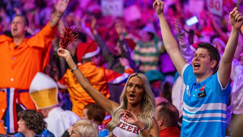 Welche Farbe hat die Triple-20? Alles rund um die Darts-WM Darts-Fans in Kostümen jubeln ihren Helden bierselig zu.
