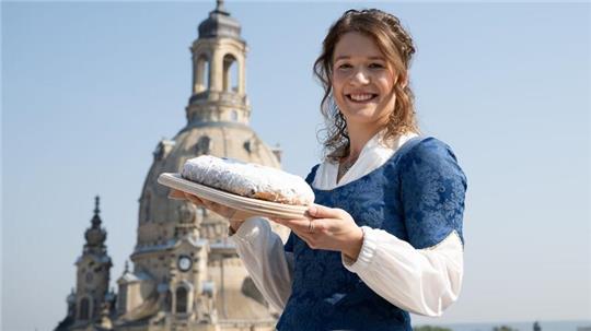 Das 30. Dresdner Stollenmädchen Lorna Prenzel mit einem der berühmten Striezel vor der Frauenkirche.