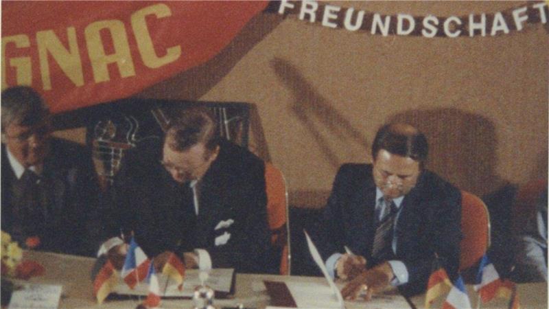 Deutsche und Franzosen: Welche Klischees stimmen - und welche nicht Das Bild zeigt den Moment der Unterzeichnung der Partnerschaftsurkunden 1985 in Blagnac. Buxtehudes Stadtdirektor Christian Hermann (links) und Bürgermeister Uwe Hampe (Mitte) sitzen mit dem Bürgermeister von Blagnac, Jacques Puig, am Tisch.