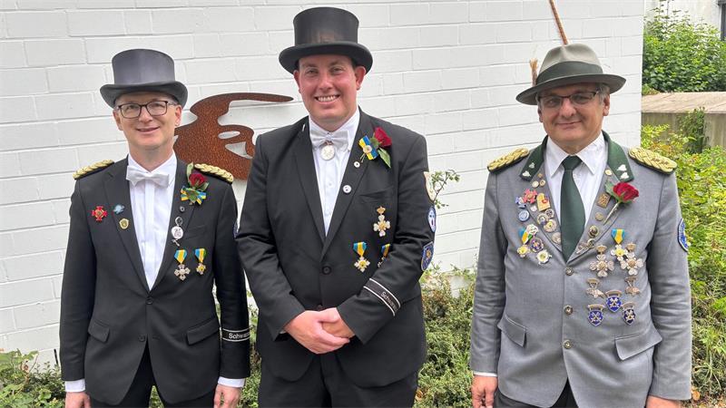 Das Bild zeigt den neuen König der Schützengilde Buxtehude, Lukas Manthe (Mitte), am Tag nach der Proklamation zusammen mit dem 1. Vorsitzenden Reinhard Meyer (links) und dem 2. Vorsitzenden Nils Lohmann vor dem Gildehaus.