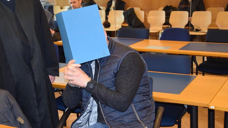 Baggersee-Mord in Buxtehude: Gerichtsmediziner berichtet von schrecklichen Details der Tatnacht Das Bild zeigt einen der vier Angeklagten, der sein Gesicht verdeckt, zum Auftakt des Baggersee-Mordprozesses im Schwurgerichtssaal des Landgerichts Stade.