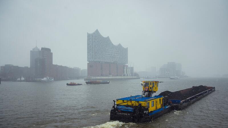 19-Jähriger stürzt von Hadag-Fähre in den Hamburger Hafen und muss reanimiert werden Das Binnenschiff "Berlin" fährt über die Elbe an der Silhouette der Hamburger Elbphilahrmonie während Schneefall und Winterwetter vorbei.