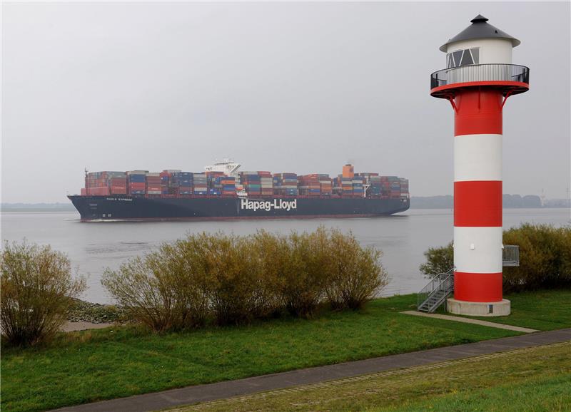 Das Containerschiff "Basle Express" Der Reederei Hapag Lloyd passiert das rot-weisse Seezeichen am Elbedeich der Ortschaft Borstel im Alten Land. Foto: dpa