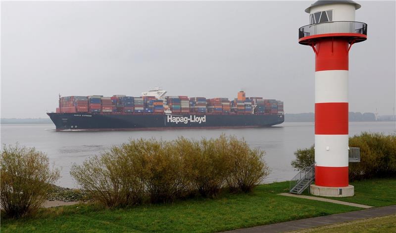 Das Containerschiff „Basle Express“ der Reederei Hapag Lloyd passiert das Seezeichen am Elbdeich in Jork-Wisch. Foto Wagner/dpa
