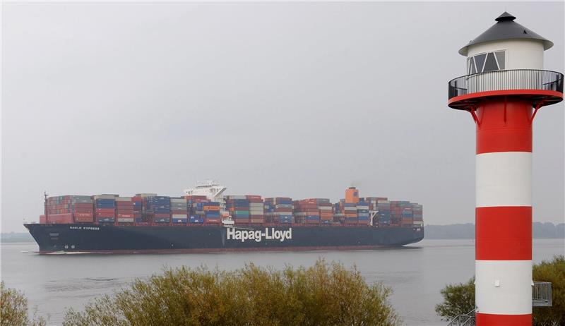 Das Containerschiff „Basle Express“ der Reederei Hapag Lloyd passiert das rot-weiße Seezeichen der Ortschaft Borstel im Alten Land. Bis zum 26. September haben die Umweltverbände Zeit, gegen den Planbeschluss zu klagen. Foto Ingo Wagner/dpa