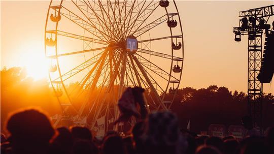 Blick auf ein Riesenrad im Sonnenuntergang auf dem Deichbrand-Festival.