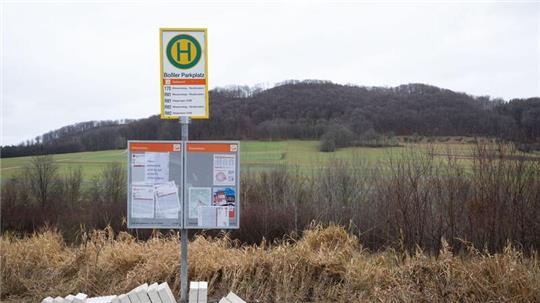 Ein Bushaltestellenschild steht in ländlichem Gelände.