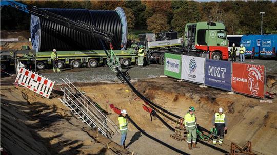 Das Erdkabel wird mit einem Schwertransporter geliefert und mit Hilfe einer Seilwinde in den Graben gehoben.