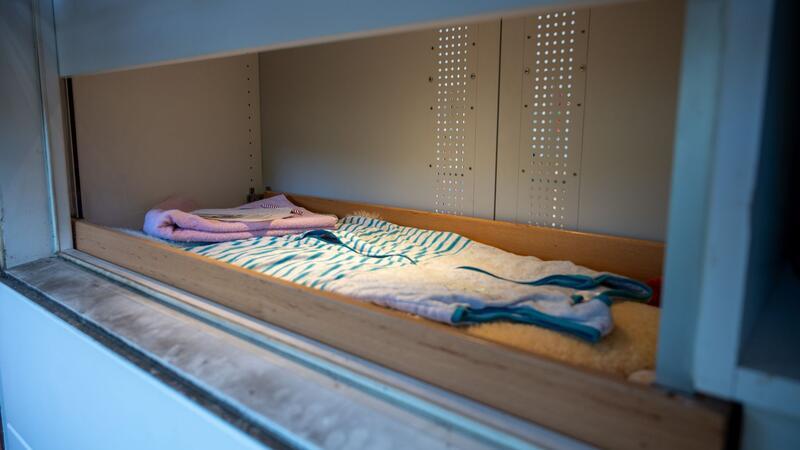 So viele Kinder waren von ihren Müttern nicht gewollt Das Fenster der Babyklappe ist geöffnet, Baby-Schlafsack, Handtuch, Decken liegen bereit.