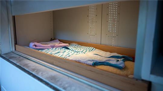 Das Fenster der Babyklappe ist geöffnet, Baby-Schlafsack, Handtuch, Decken liegen bereit.