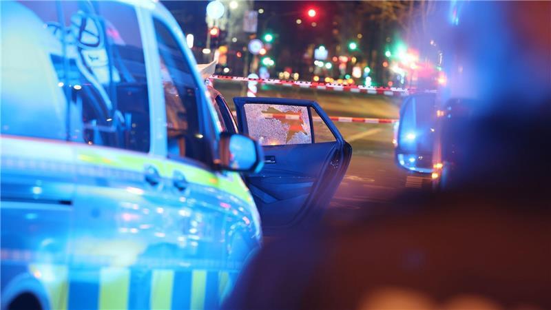 Das Fenster eines Autos ist zersplittert, während die Polizei an einem Tatort in Düsseldorf im Einsatz ist.