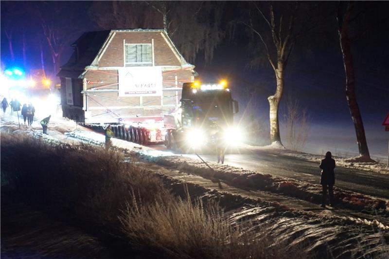 Das Flüchtlingssiedlungshaus wird über verschneite Straßen mit Polizeibegleitung auf dem Weg von Tostedt zum Kiekeberg gefahren. Fotos: FMAK