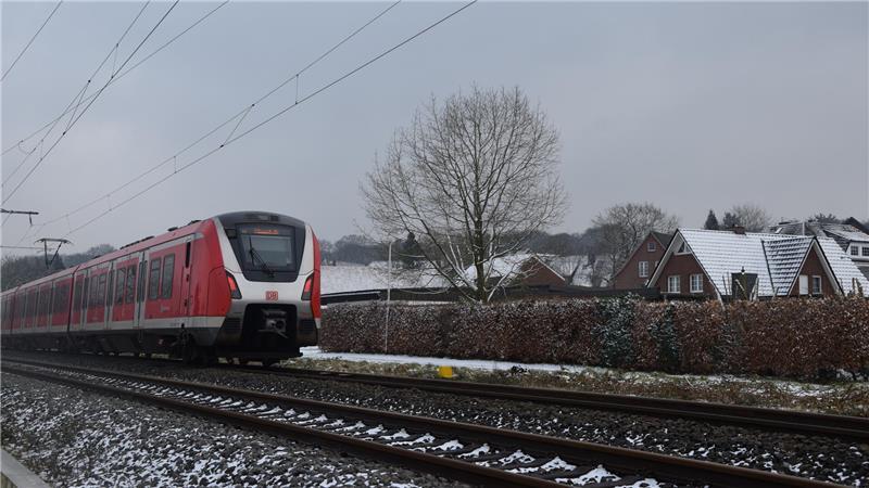 Das Foto aus dem Jahr 2025 zeigt einen S-Bahn-Zug, der nahe des Bahnhofs Neukloster an Wohnhäusern entlangfährt. In der Ortsdurchfahrt Neukloster will die Bahn Lärmschutzwände errichten.