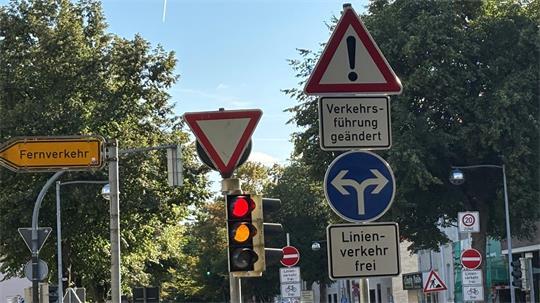 Das Foto zeigt den Verkehrsschilderwald mit Blick aus der Straße Zwischen den Brücken auf die Bahnhofstraße. Alle Anweisungen auf einem Blick zu erfassen, ist herausfordernd für Verkehrsteilnehmer.