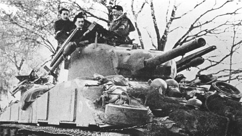 Das Foto zeigt zwei Tote von Kutenholz, Frank Lock (links) und Stanley Somerset (rechts), auf einem Sherman-Panzer bei Namur. Vorne links ist der Captain Robert Thomas Boscawen zu sehen, er wurde am 1. April schwer verwundet, die beiden Guardsmen starben am 1. Mai 1945.