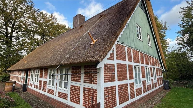 Das Heimathaus Wangersen hat ein neues Reetdach. Die Stäbe, die auf dem Dach angebracht wurden, sind Blitzableiter.