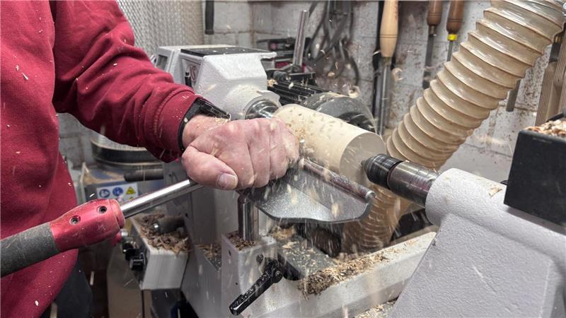 Das Holzstück dreht sich an der Drechselbank. Mit dem Drechseleisen formt Bernd Peters es zurecht.