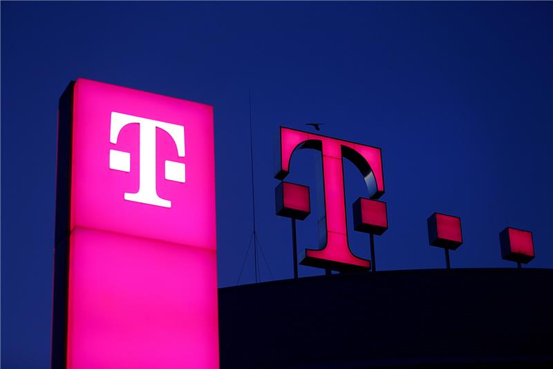 Das Logo der Deutschen Telekom leuchtet auf dem Dach der Unternehmenszentrale. Foto: Oliver Berg/dpa