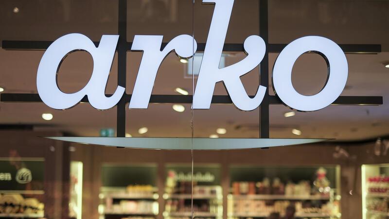 Das Logo der Firma arko leuchtet in Hamburg am Eingang einer Filiale.