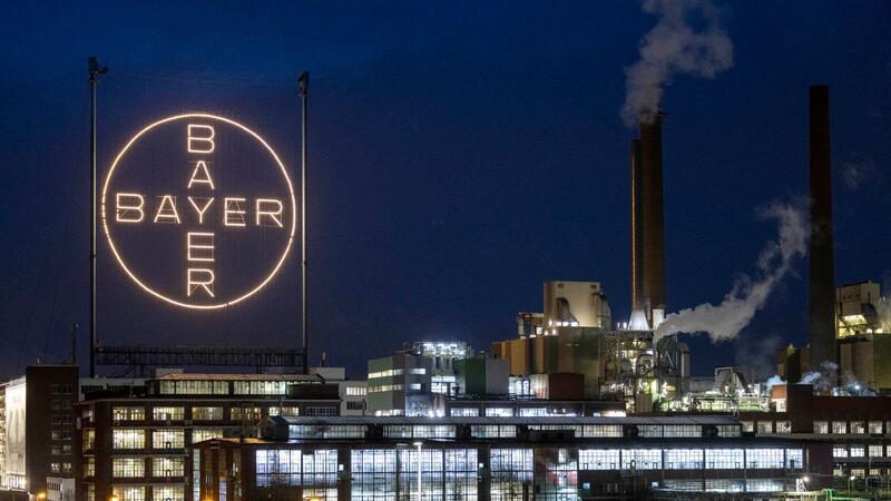 Das Logo des Unternehmens leuchtet auf dem Werksgelände in Leverkusen.