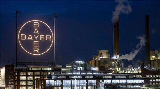 Das Logo des Unternehmens leuchtet auf dem Werksgelände in Leverkusen.